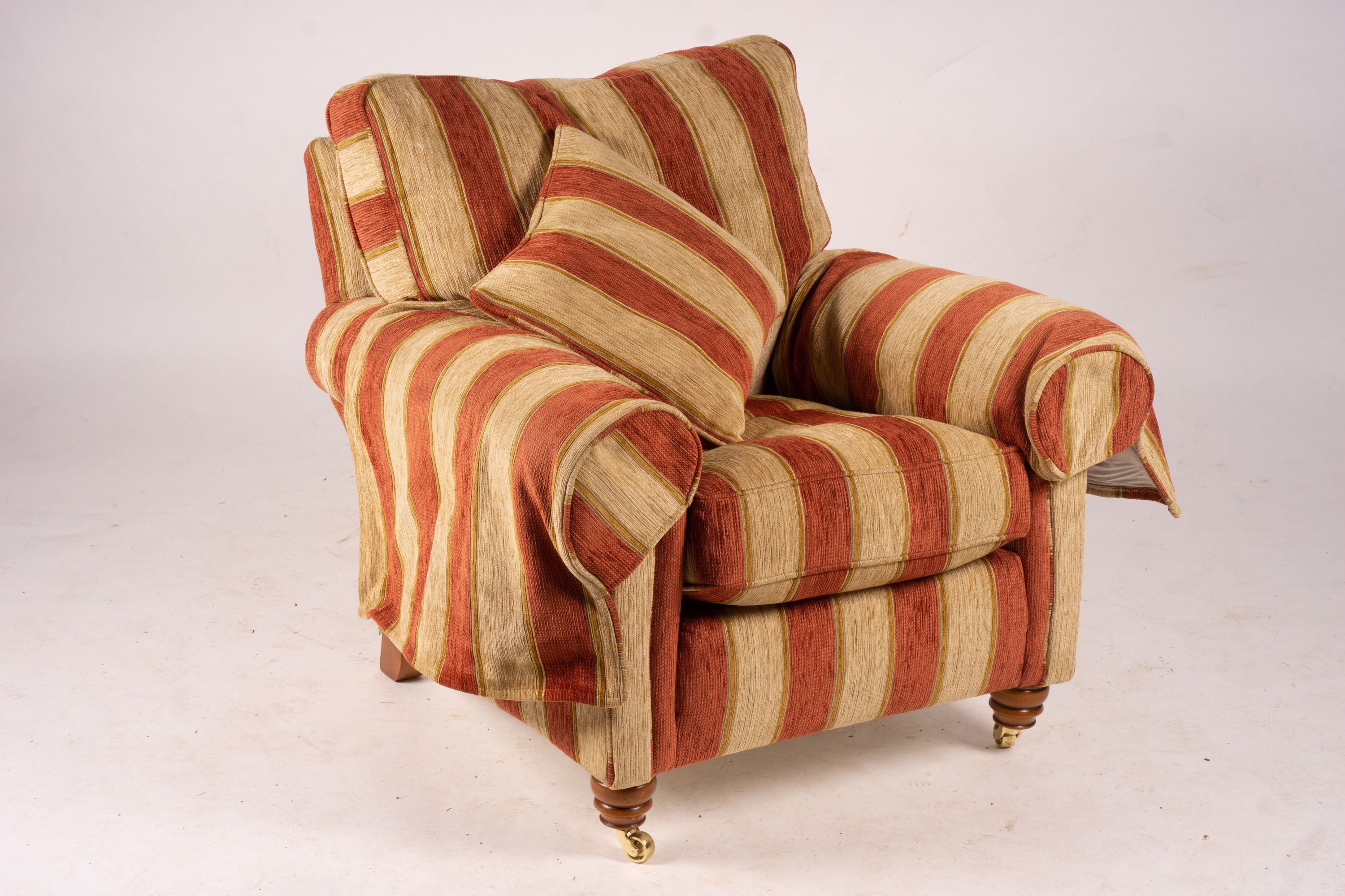 A pair of Duresta armchairs, width 94cm, depth 90cm, height 90cm and matching footstool in striped red and gold fabric